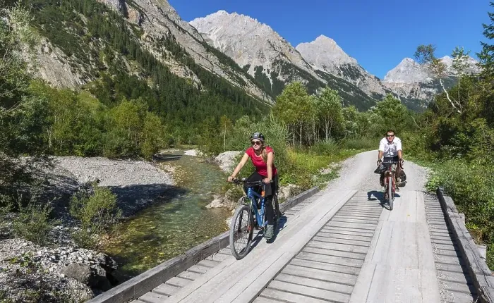 Framed Print : Cyclists, mountain bikers cycle on bridge over mountain stream Framed Print : Cyclists, mountain bikers cycle on bridge over mountain stream