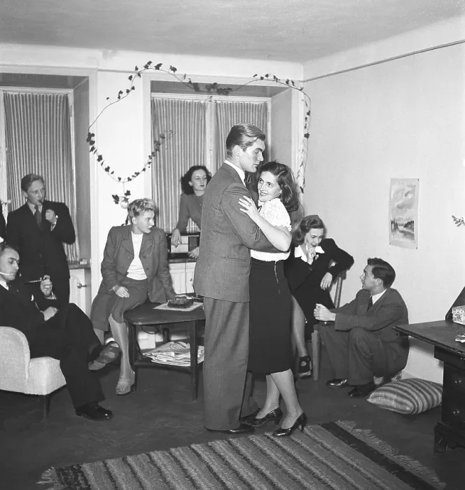 Framed Print : Dancing in the 1940s. A young people at a party is dancing while their friends are sitting Framed Print : Dancing in the 1940s. A young people at a party is dancing while their friends are sitting