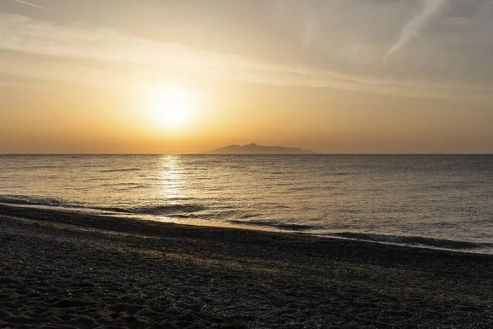 Framed Print : Dawn at sunrise, view from the lava beach Kamari to the island of Anafi