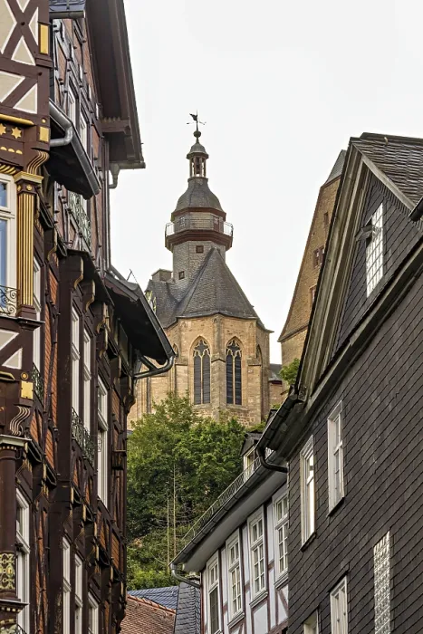 Framed Print : Detailed architecture shows half-timbered houses and a church above the roofs Framed Print : Detailed architecture shows half-timbered houses and a church above the roofs