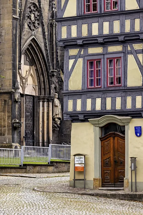 Framed Print : Detailed view of a church portal next to a half-timbered house Framed Print : Detailed view of a church portal next to a half-timbered house