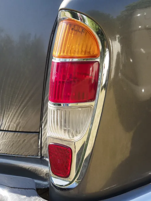 Framed Print : Detailed view of a tail light on a vintage car with chrome trim