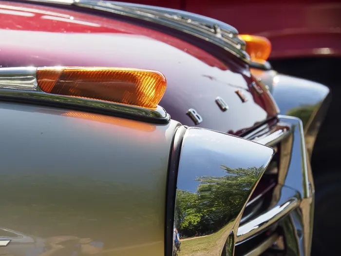 Framed Print : Detailed view of a vintage car with red paintwork and chrome accents