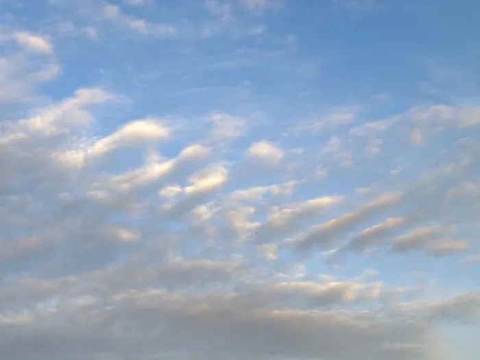 Framed Print : Diagonally arranged stratocumulus clouds are illuminated by warm sunlight at dusk