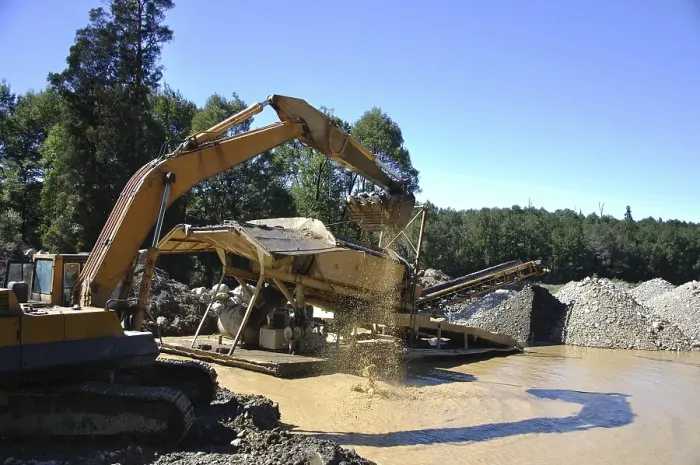 Framed Print : Digger feeding gravel into small gold screen