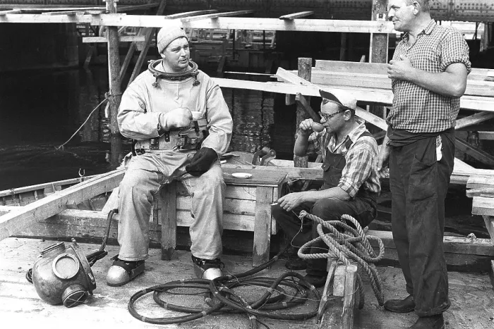 Framed Print : A diver in 1953, sitting in his diving suit and drinking coffee