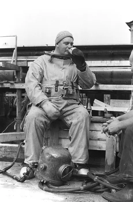 Framed Print : A diver in 1953, sitting in his diving suit and drinking coffee