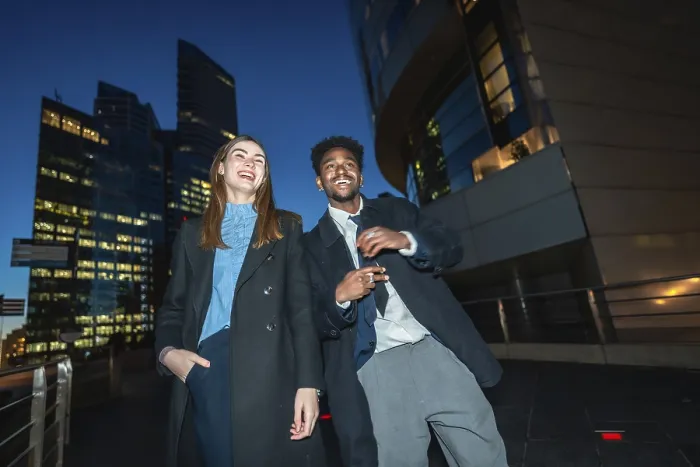 Framed Print : Diverse businesspeople enjoying a joyful moment together while standing on a promenade with illuminated city