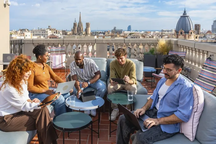 Framed Print : Diverse colleagues brainstorm and collaborate on laptops and tablets on a vibrant rooftop terrace in barcelona