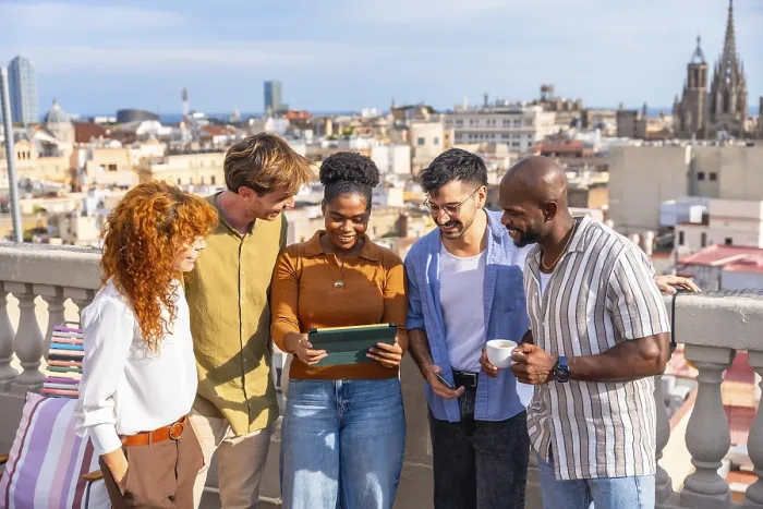 Framed Print : Diverse colleagues networking and smiling on a sunny barcelona rooftop during a casual work break