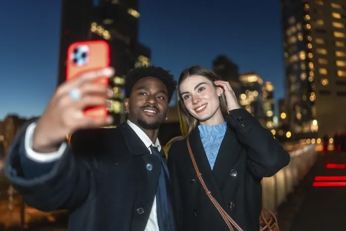 Framed Print : Diverse couple happily capturing a moment together using a mobile device for a selfie