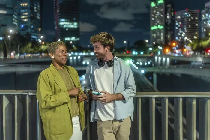 Framed Print : Diverse young couple chatting and smiling on an urban bridge at night