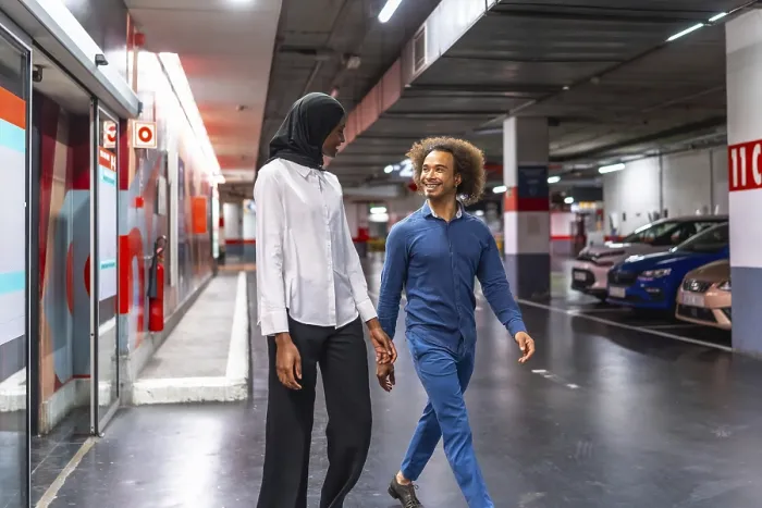 Framed Print : Diverse young couple walking hand in hand through an underground parking garage Framed Print : Diverse young couple walking hand in hand through an underground parking garage