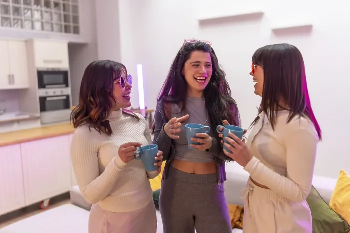 Framed Print : Three diverse young women laughing and talking while holding coffee mugs Framed Print : Three diverse young women laughing and talking while holding coffee mugs