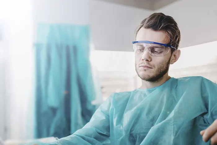 Framed Print : Doctor seated in scrubs, appearing calm and thoughtful with goggles