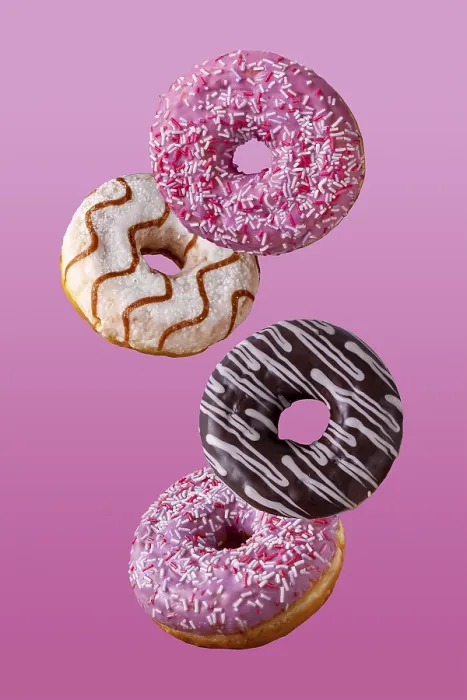 Framed Print : Donuts in chocolate and in sugar glaze fly on a pink background