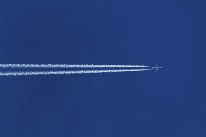 Framed Print : Double contrails behind airplane in the blue sky