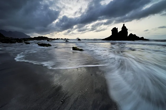 Framed Print : Dramatic clouds with rock formation at rising tide at the beach of Playa de Benijo