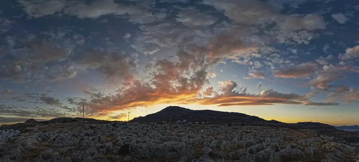 Framed Print : Dramatic landscape of Lindos with a mountain in the background and colourful sunset in the sky