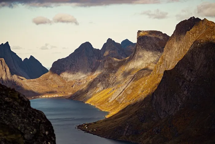 Framed Print : Dramatic view of a fjord with towering mountains casting shadows along the landscape