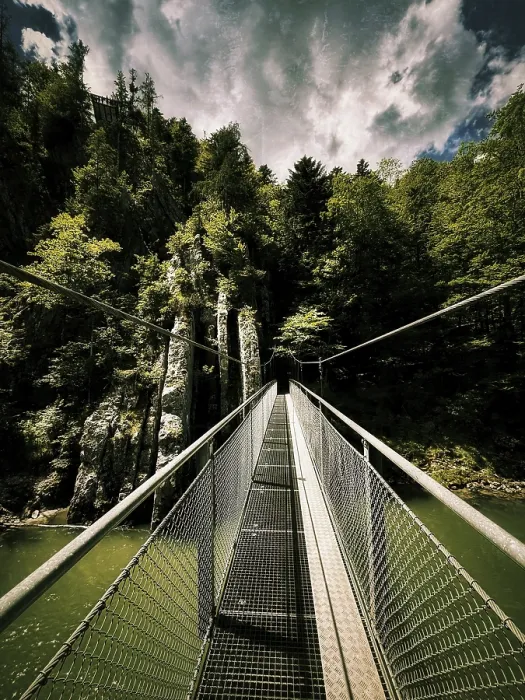 Framed Print : Dramatic view of a suspension bridge over a gorge with rocks Framed Print : Dramatic view of a suspension bridge over a gorge with rocks