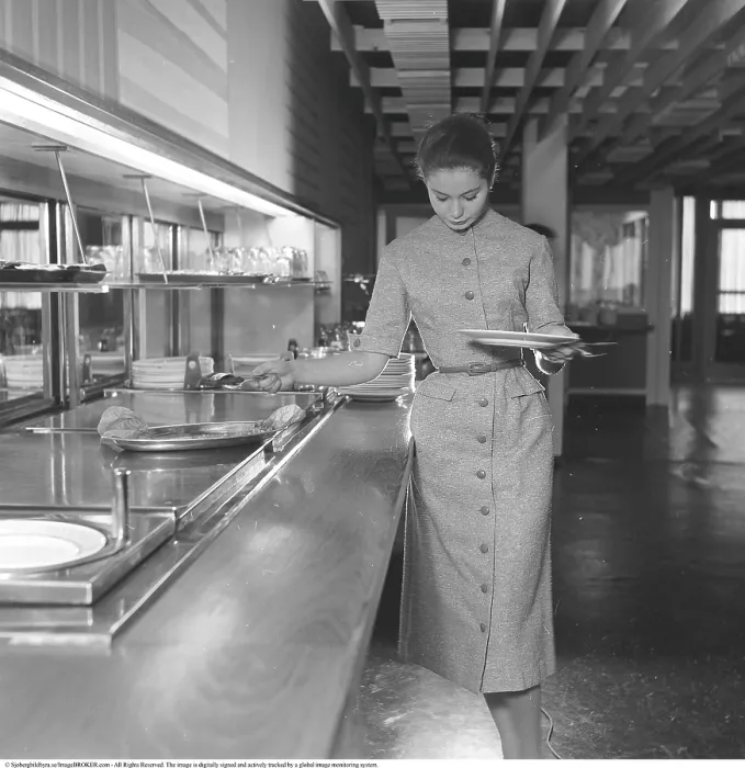 Framed Print : She dressed nicely 1956. The young model is helping herself to the food at the restaurant
