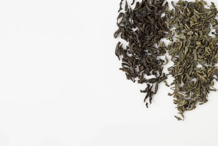 Framed Print : Dried black and green tea leaves on white background