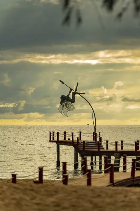 Framed Print : Dynamic sculpture of an acrobat on a pier against an ocean sunset with dramatic clouds Framed Print : Dynamic sculpture of an acrobat on a pier against an ocean sunset with dramatic clouds