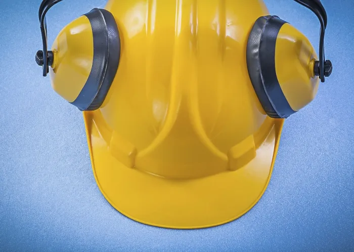 Framed Print : Ear muffs hard hat on blue background construction concept