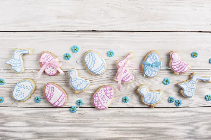 Framed Print : Easter frosted cookies in shape of egg chicken and rabbit on white wooden table background along with sugar sprinkles