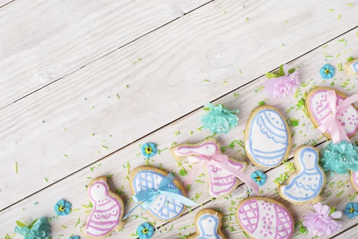 Framed Print : Easter frosted cookies in shape of egg chicken and rabbit on white wooden table background along with sugar sprinkles
