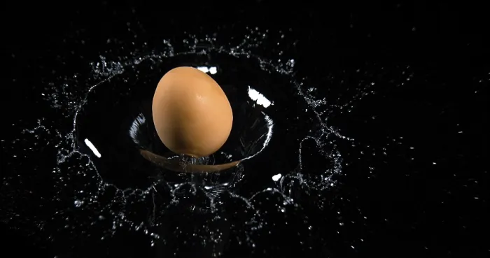 Framed Print : Egg Falling on Water against Black Background