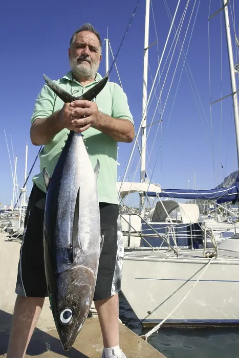 Framed Print : Elderly fisherman with Albacore tuna catch in hands