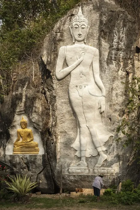 Framed Print : Elderly woman standing in front of a Buddha sculpture