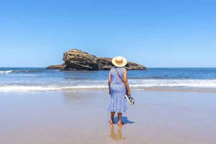 Framed Print : An elderly woman on vacation looking at the sea on the beach in Biarritz