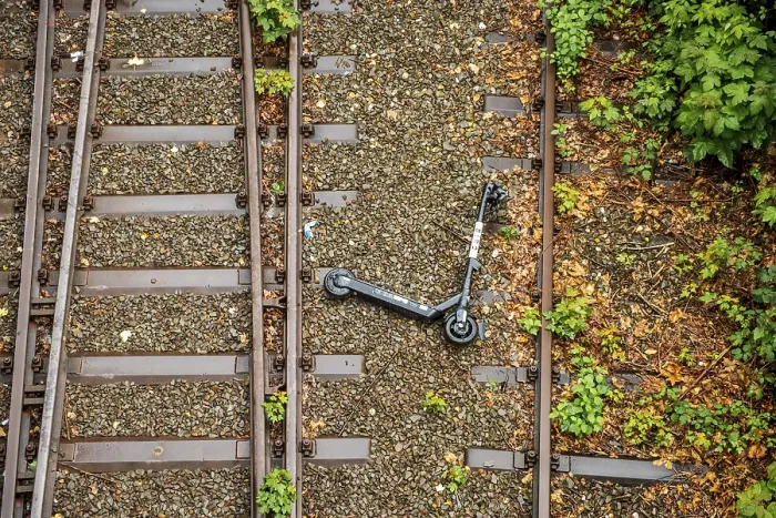 Framed Print : An electric scooter lies overturned between two railway tracks in Dusseldorf