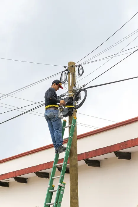 Framed Print : Electrician on ladder working on electricity power lines