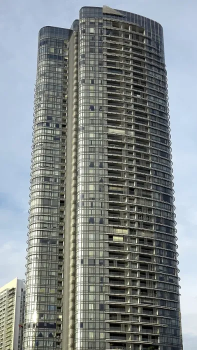 Framed Print : Elegant tall building with curved glass facade under a slightly cloudy sky Framed Print : Elegant tall building with curved glass facade under a slightly cloudy sky