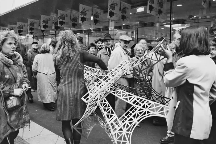 Framed Print : Employees carry a model of the Eiffel Tower across the pavement at the opening of the French department stores
