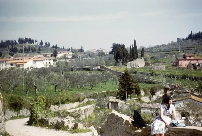Framed Print : English tourist sitting on a wall in a village, Italy 1957