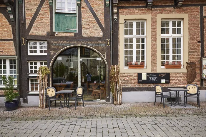 Framed Print : Entrance area of a restaurant in a historic half-timbered brick house with white