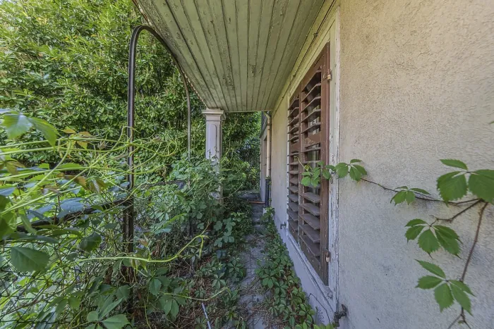 Framed Print : Entrance to the overgrown garden of a multi-storey residential building built in 1903 in front of demolition work