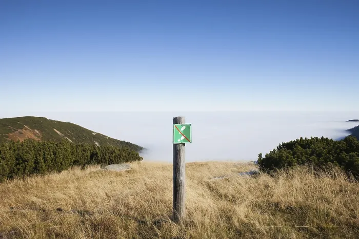 Framed Print : No entry warning sign on a meadow at precipice on mountain peak