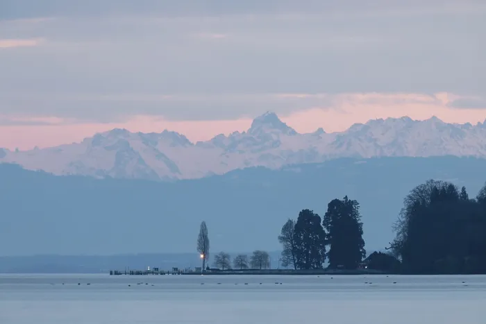 Framed Print : Evening light turns the sky pink over a peaceful lake with mountains