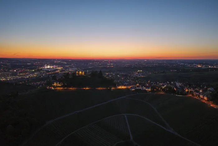Framed Print : Expansive city view at dusk, with illuminated chapel and vineyards