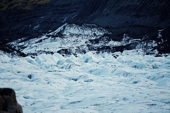 Framed Print : Expansive glacier with jagged icy waves amid dark mountain backdrop
