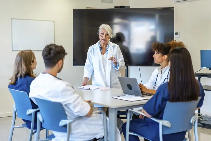 Framed Print : Experienced doctor explaining a new treatment to her colleagues during a medical training Framed Print : Experienced doctor explaining a new treatment to her colleagues during a medical training
