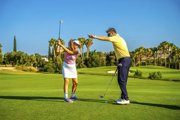 Framed Print : Experienced golf instructor guiding a female golfer on a sunny day