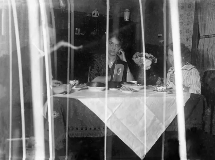Framed Print : Family sitting at the dining table behind a curtain