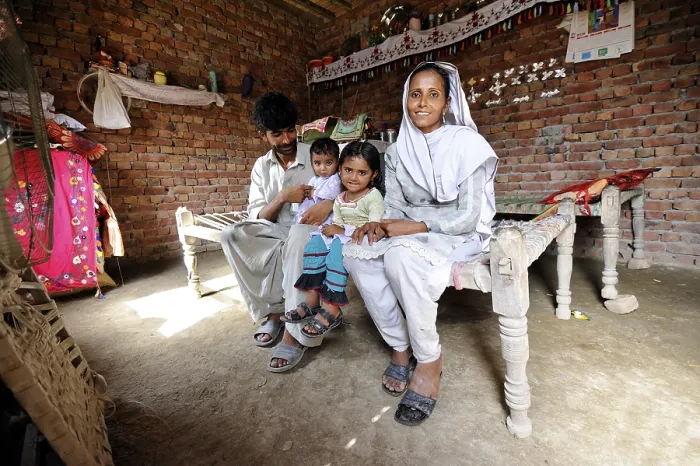 Framed Print : Family sitting in a new house made of bricks that they received from a relief organisation Framed Print : Family sitting in a new house made of bricks that they received from a relief organisation